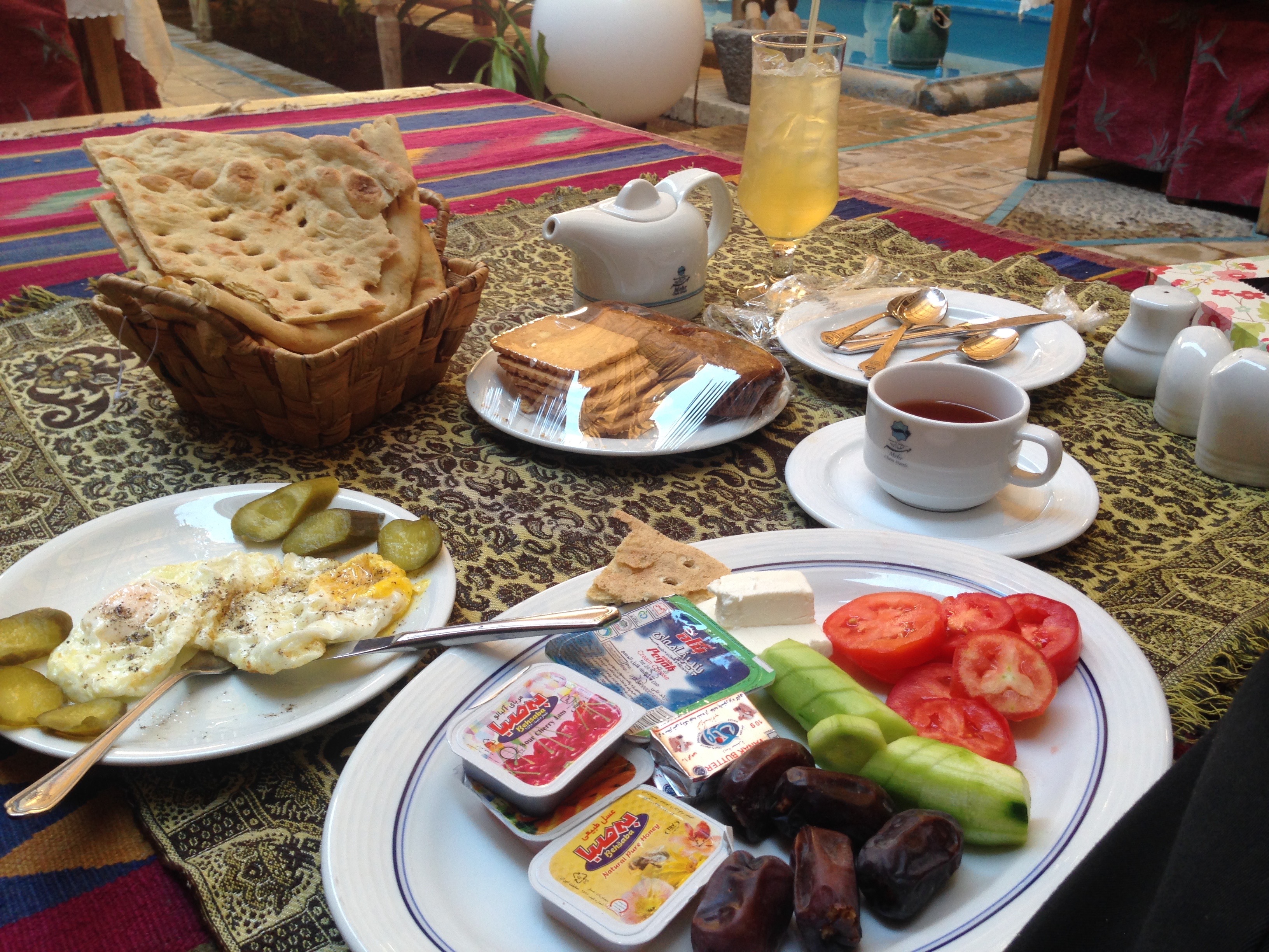 A Persian breakfast spread photographed in Yazd, Iran: flatbread, white cheese, fresh herbs, preserves and tea