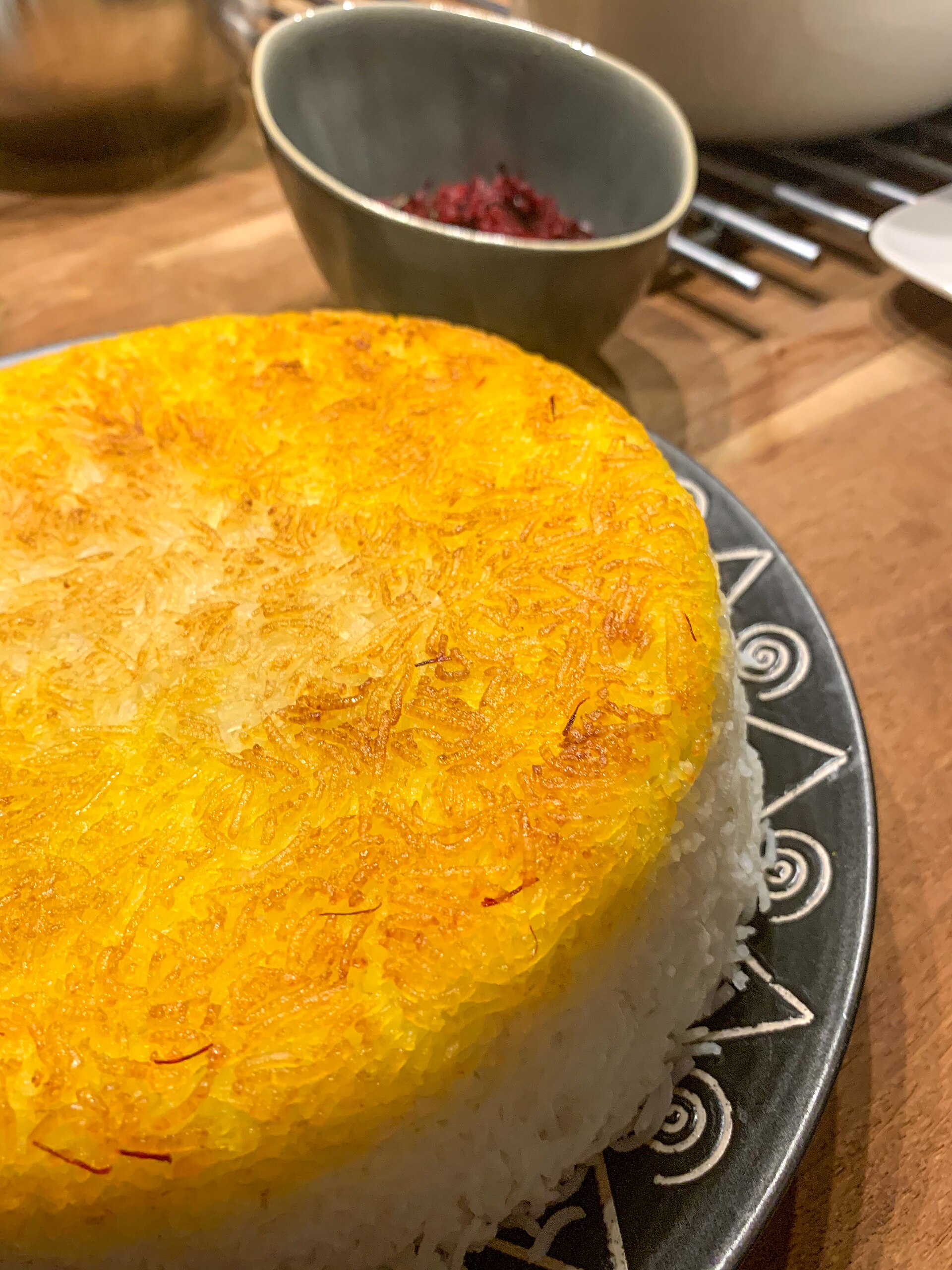 A whole saffron-yellow rice crust on top of a turned-out mound of rice.