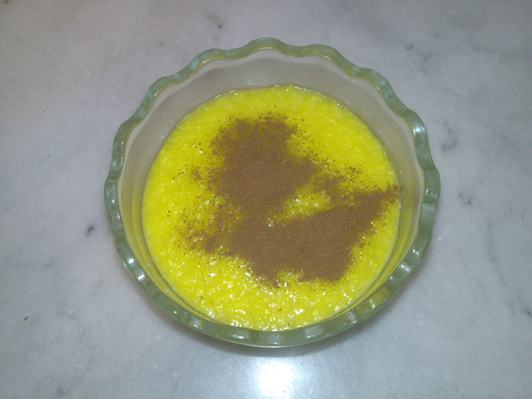 Sholeh zard — Persian saffron rice pudding decorated with cinnamon.