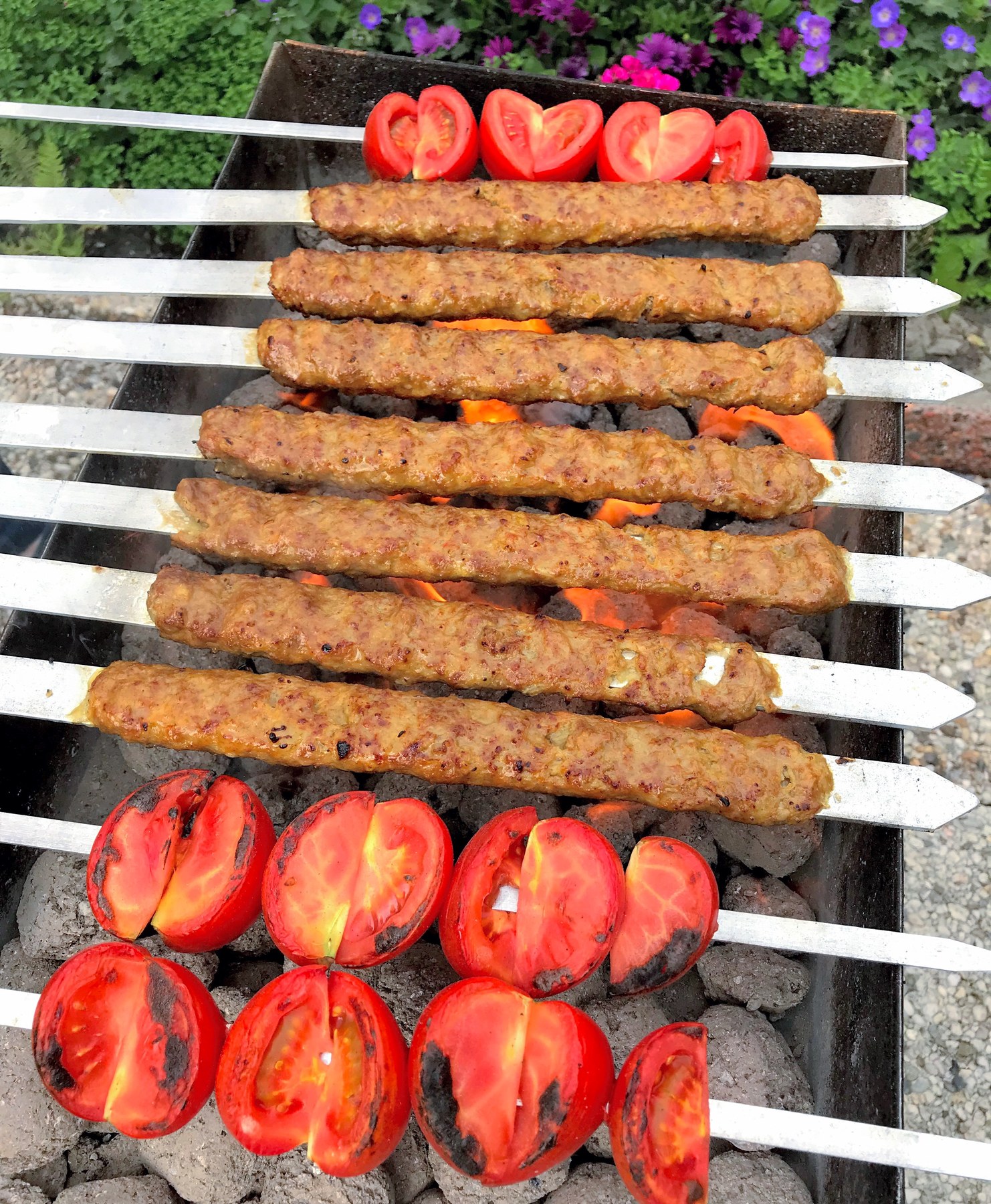 Kabab koobideh — Persian minced meat kababs grilling over charcoal.