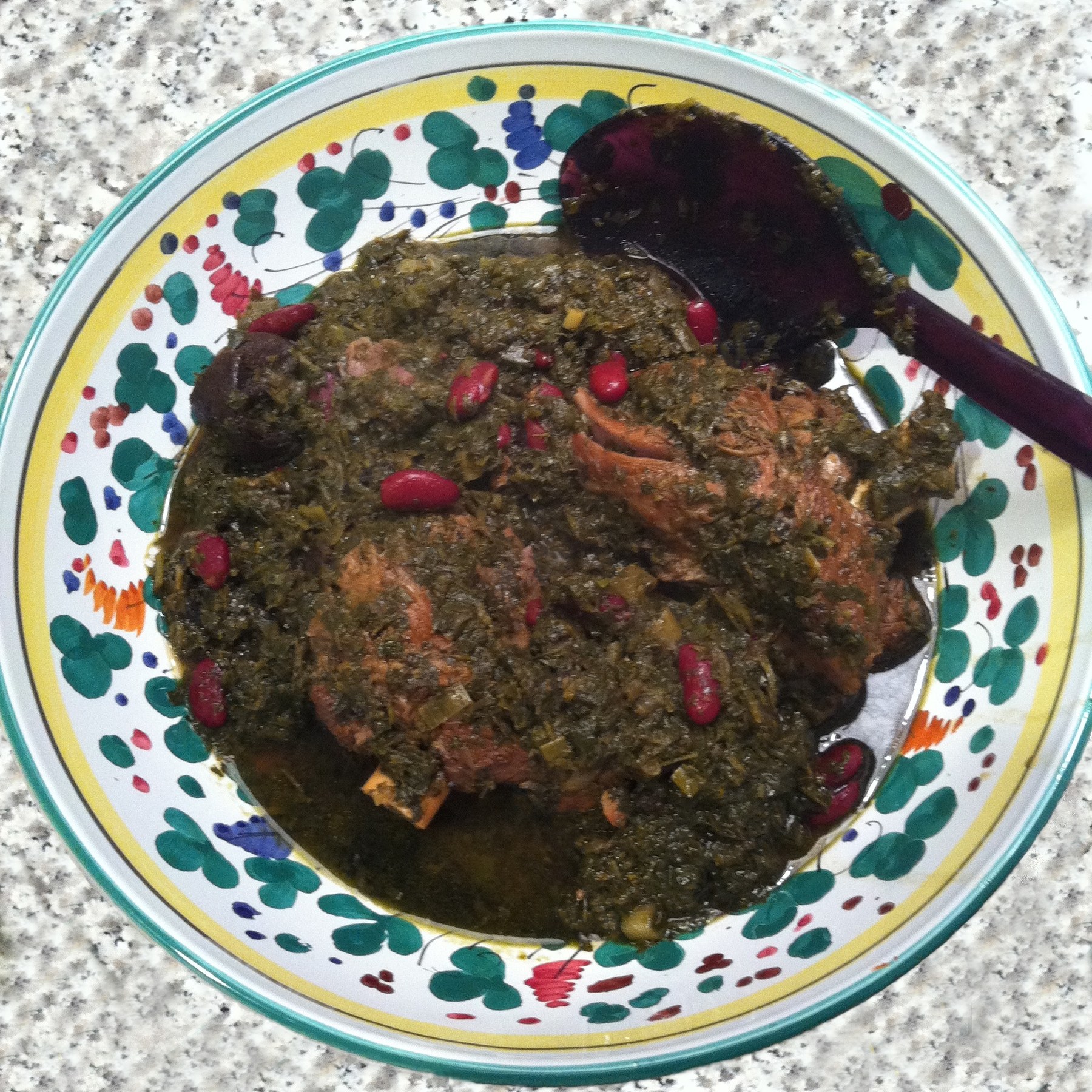 A bowl of ghormeh sabzi, a dark green Persian herb stew with kidney beans.